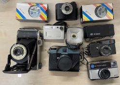 A mixed lot of various cameras, both vintage and modern.