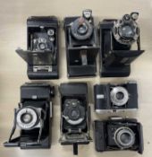 Seven vintage folding cameras to include: Kodak No. 1 Pocket; Kodak No. 0; Agfa; Zeiss Ikon;