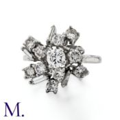 A Diamond Cluster Ring in platinum, set with round and baguette cut diamonds totalling approximately