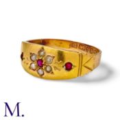 A Ruby And Pearl Gypsy Ring in 15k yellow gold, the stylised band set with a ruby within a cluster