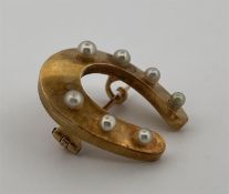 14kt yellow gold horseshoe brooch set with imitation pearls.
The brooch features 7 imitation pearls,