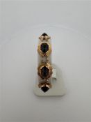 14kt yellow gold bracelet with garnet.
The bracelet is set with 9 imitation garnet gemstones. The st