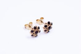 14kt yellow gold rosette stud earrings set with garnet.
The ear studs are each set with 5 rose cut g