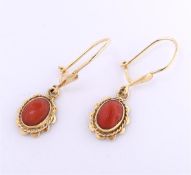 9 carat red coral earrings, each set with an oval cut red coral of approximately 7 mm, set in a grac
