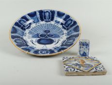 A lot of earthenware consisting of a large peacock dish, a vase and an orange blue tile. 17th & 18th