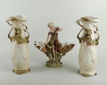 An Art Nouveau porcelain garniture depicting a fisherwoman on a rock flanked by two shell-shaped bow