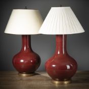 A PAIR OF COPPER-RED BOTTLE VASES MOUNTED AS LAMPS