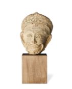 A HARIPUNJAYA FRAGMENTARY HEAD OF A MALE DEITY, NORTHERN THAILAND, CIRCA 13TH CENTURY