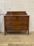 An Edwardian walnut ledge back chest, fitted with two short and two long drawers, raised on square