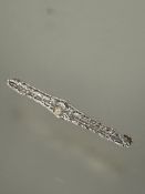 A Edwardian 14ct gold and white metal filigree brooch set central pearl flanked by bright cut leaves