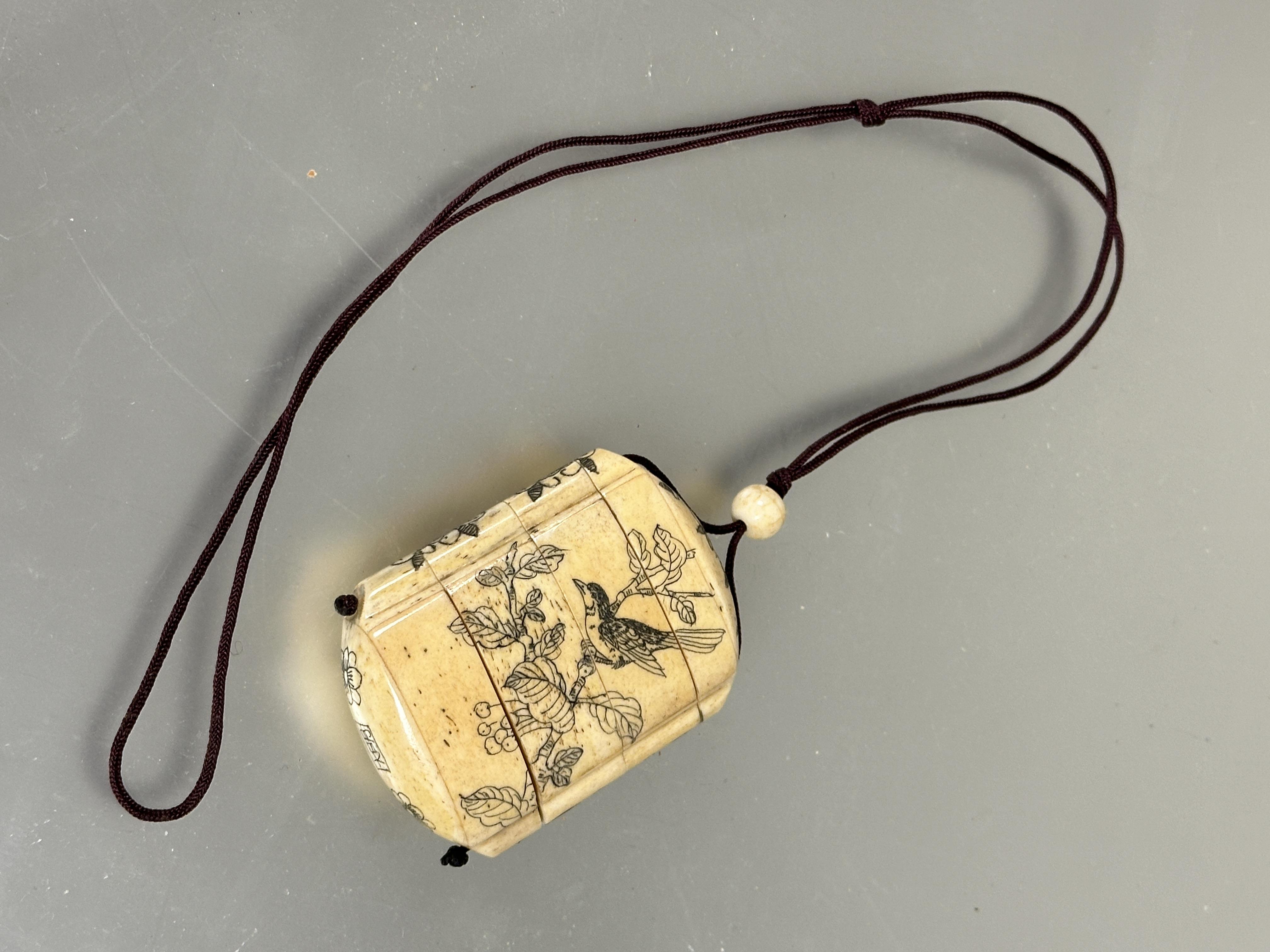 A modern Japanese style carved bone Inro mounted on burgundy cord and bead Ojime and four sections