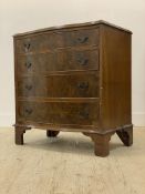 An early 20th century figured walnut serpentine chest of four long graduated drawers, raised on