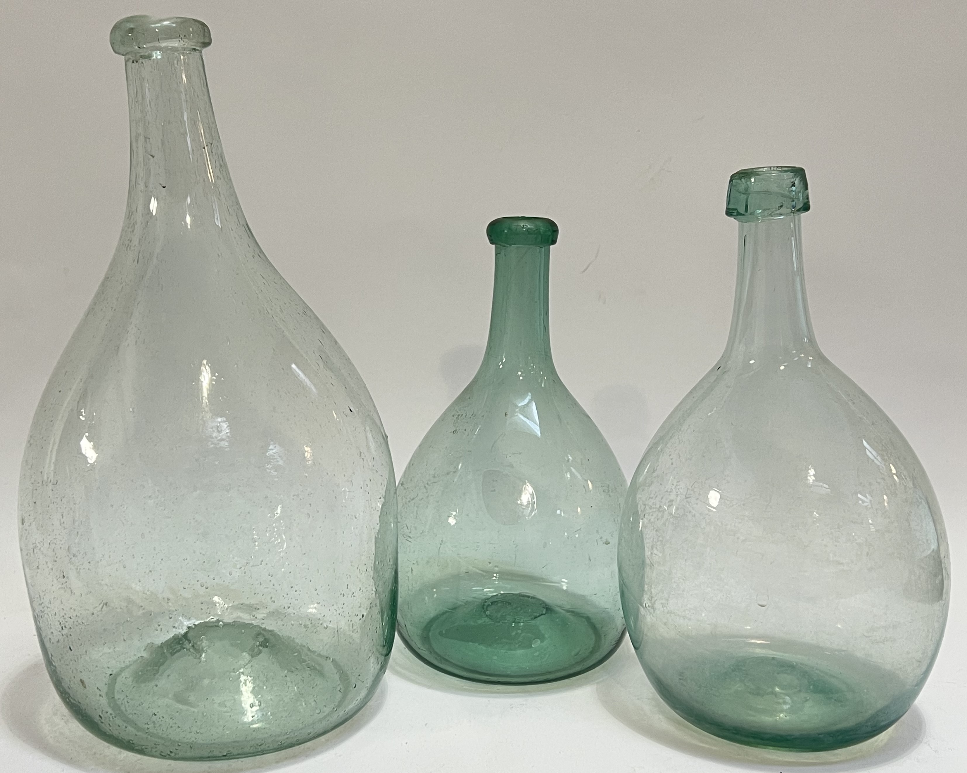 Three early American (18th/19th century) blown glass onion bottles (largest h- 31cm)