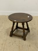 An 18th century style oak lamp table, the circular top raised on turned and block supports united by