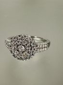 A 18ct gold diamond cluster ring, the central diamond 0.17ct enclosed within two bands of diamond