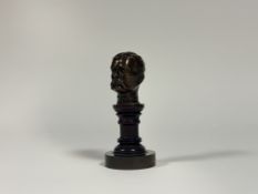 A desk-top bronze bust of Lord Kitchener, early 20th century, dark brown patina, mounted on a turned