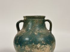 An Islamic, Kashan, glazed pottery twin-handled jar, probably 12th/13th century, with iridescent