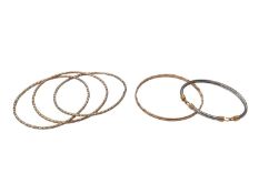 9ct three colour gold triple bangle, one other 9ct gold bangle and a yellow and white metal bangle (