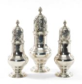 SET OF THREE GEORGE II SILVER CASTERS having pierced lid and spiral knop terminal, circular foot,