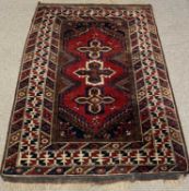 EASTERN WOOLEN RUG, red ground, repeating central pattern block, triple border, tassled ends, 193