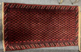 PERSION RED GROUND HANDMADE WOOL RUG, geometric border, 144 x 84cms Provenance: deceased estate