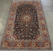 FINE KASHAN RUG, navy blue and burgundy ground, repeating diamond border with sunburst central