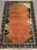 MODERN WOOLLEN RUG, ground rust coloured and multi-patterned, 185 x 120cms Provenance: Private
