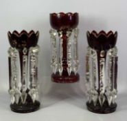 VICTORIAN RUBY GLASS LUSTRES A PAIR, with gilded highlights and clear cut glass drops, 34.5cms (h)