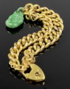 GOLD CURB LINK BRACELET, with heart shaped padlock marked 15ct, with a jade type charm attached,