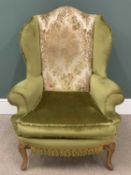 ANTIQUE WING BACK ARMCHAIR, classically upholstered in green and gold, on scrolled and carved