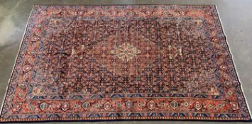 EASTERN SAROUGH WOOLLEN RUG red ground with central diamond and repeating border pattern, 336 x
