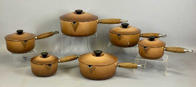 LE CREUSET SET OF SIX GRADUATED CAST IRON & BROWN ENAMEL SAUCEPANS with wooden handles Provenance: