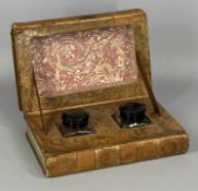 A PAIR OF GLASS INKWELLS with Bakelite caps contained within a box formed as two leather bound