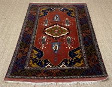 AFGHAN HERATI RUG, central medallion on a shaped deep red plain field, with six motifs, shaped