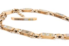 YELLOW METAL ALBERT TEN PANEL CHAIN set with believed gold quartz, T-bar with further believed