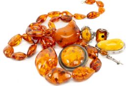 ASSORTED AMBER JEWELLERY, including two silver mounted rings, three silver mounted brooches (one