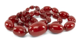 CHERRY AMBER BAKELITE BEAD NECKLACE, of medium red tone, strung with graduated oval beads from