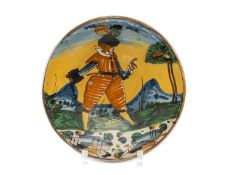 17TH C. MONTELUPO MAIOLICA DISH, painted with a striding soldier in orange striped uniform in