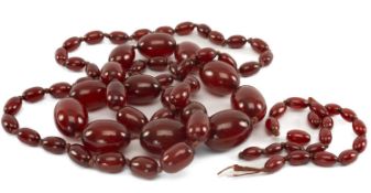 CHERRY AMBER BAKELITE BEAD NECKLACE, of deep red tone, strung with graduated oval beads from 25mm to