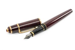 CARTIER MAROON RESIN 'DIABLO DE CARTIER' FOUNTAIN PEN, cap with red cabochon finial, gilt metal