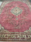 ANTIQUE PERSIAN WOOL CARPET with red ground, plain section with foliate pattern and central cream