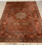 LARGE KESHAN RUG, rust/red ground with multifloral border, central oblong and star pattern