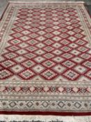 PERSIAN WOOLLEN RUG of red and cream ground, multi-border with repeating diamond pattern throughout,