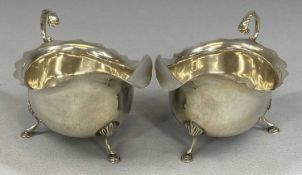 PAIR OF GEORGE VI SILVER SAUCE BOATS with acanthus capped loop handles, wavy rims and on hoof