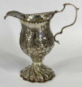 GEORGE III SILVER CREAM JUG of helmet form, with crimped rim, shaped loop handle, on circular