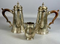 EDWARD VII SILVER CHOCOLATE POTS A PAIR, left and right facing with wooden side handles and domed