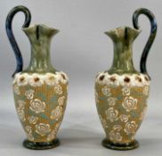 ROYAL DOULTON STONEWARE EWERS A PAIR, the shoulders decorated with a band of applied flowers, the