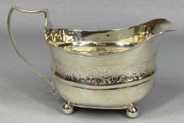 GEORGE III SILVER MILK JUG of oval form with loop handle, engraved with band of leaves, on ball