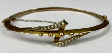 9CT GOLD HOLLOW BANGLE set with split seed pearls, hinged with safety chain, 45 x 16mms, 5.3gms