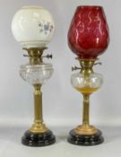 TWO VICTORIAN OIL LAMPS having black ceramic bases, brass columns, cut glass reservoirs, twin